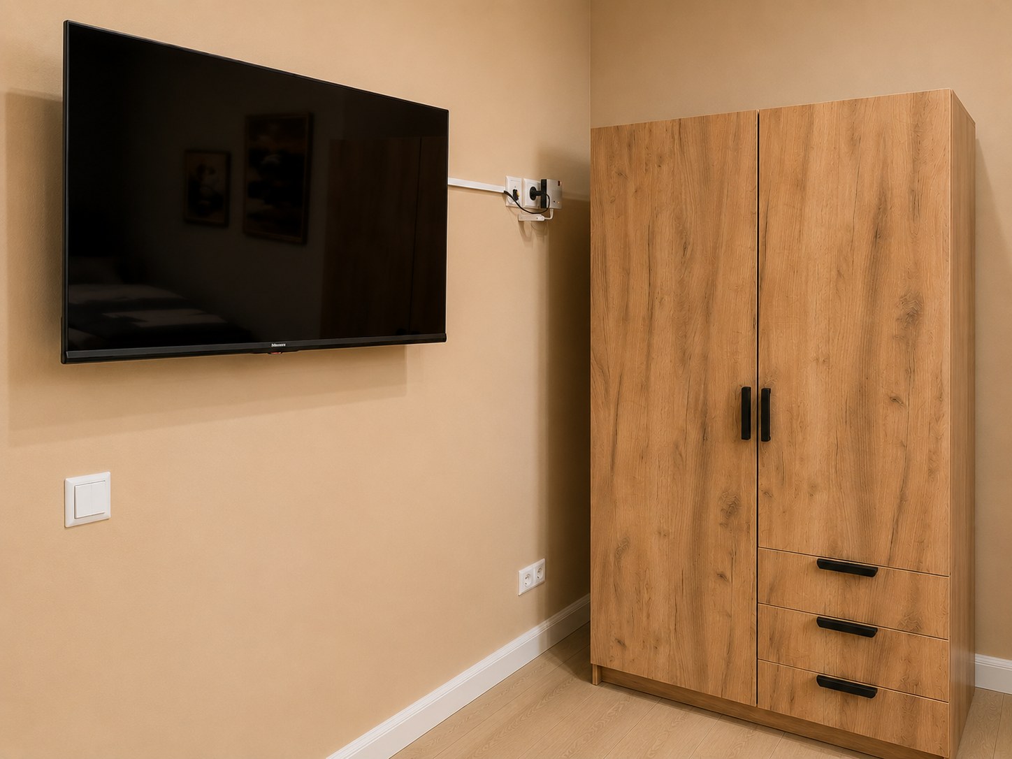 Modernes Einzelzimmer der HK Vermietung mit Flachbildfernseher, großem Kleiderschrank und hochwertiger Einrichtung.