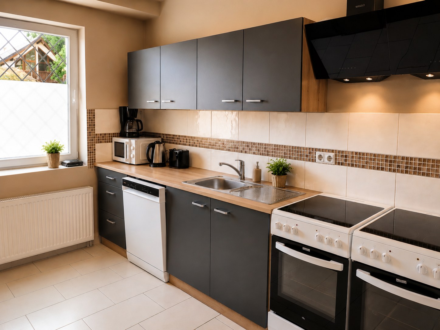Moderne Gemeinschaftsküche der HK Vermietung in Brieselang mit Herd, Backofen, Geschirrspüler, Mikrowelle, Kaffeemaschine und Wasserkocher für Monteure und Geschäftsreisende nahe Berlin.