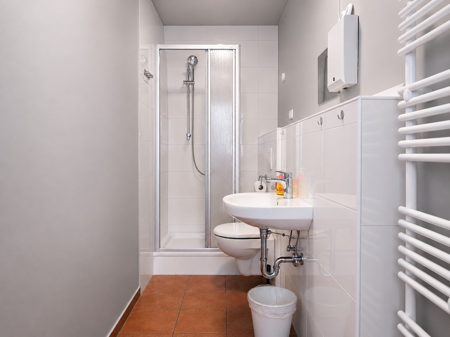 Helles Gemeinschaftsbad mit Dusche und Waschbecken in der HK Vermietung nahe Berlin.